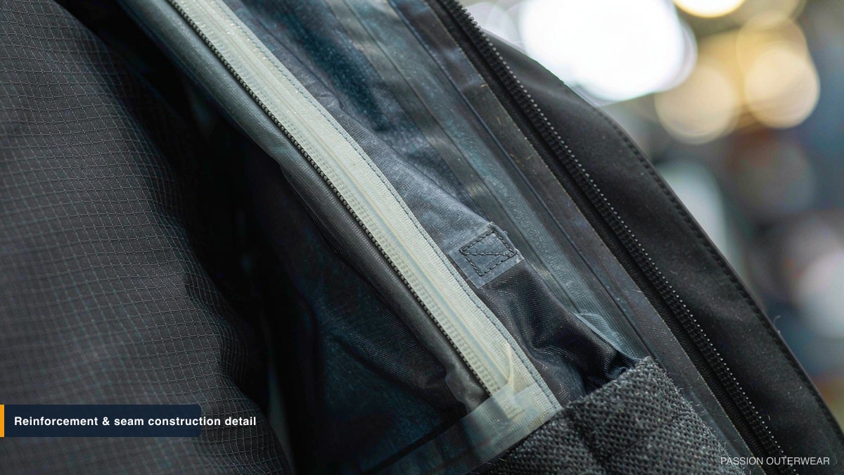 Close-up of reinforced ripstop fabric, taped seam and bar-tack stitching on a technical ski pant